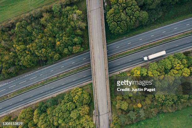 drone point of view of an articulated lorry on a major road - uk road stock pictures, royalty-free photos & images