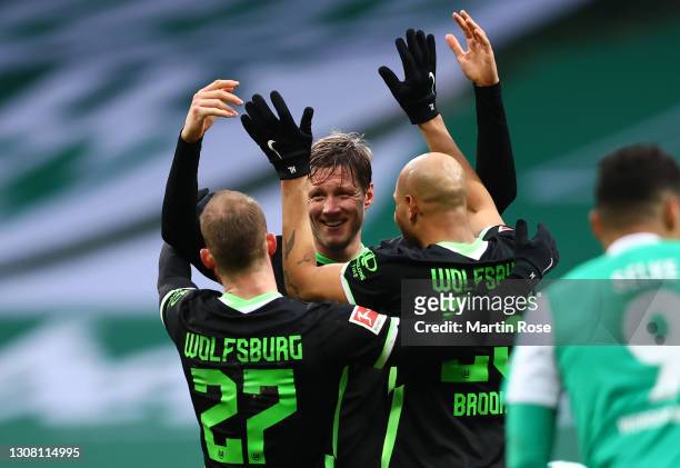 Maximilian Arnold, Wout Weghorst and John Brooks of VfL Wolfsburg celebrate after the Bundesliga match between SV Werder Bremen and VfL Wolfsburg at...