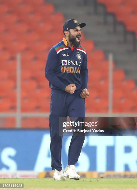 Virat Kohli celebrates the wicket of Jos Buttler, bowled by Bhuvneshwar Kumar and caught by Hardik Pandya during the 5th T20 International between...