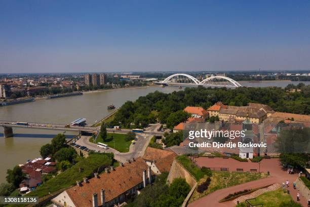 drone view petrovaradin fortress clock tower and river danube - serbian flag stock pictures, royalty-free photos & images