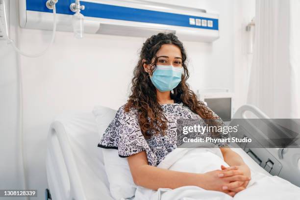female patient in mask lying on hospital bed - protective face mask happy stock pictures, royalty-free photos & images