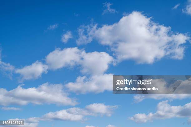 beautiful white puffy clouds against blue sky - wolkenlandschap stockfoto's en -beelden