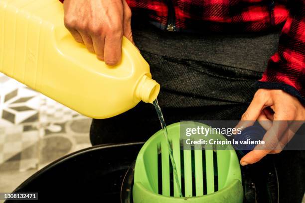 close-up of bleach pot pouring into a bucket - daily bucket fotografías e imágenes de stock