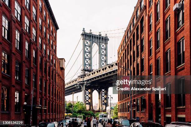 street in dumbo brooklyn with manhattan bridge between buildings, new york, usa - brooklyn new york foto e immagini stock