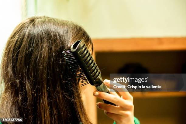 young woman brushing hair - woman brushing hair stock pictures, royalty-free photos & images