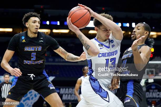 Christian Bishop of the Creighton Bluejays is pressured by Brandon Cyrus of the UC Santa Barbara Gauchos during the first half in the first round...