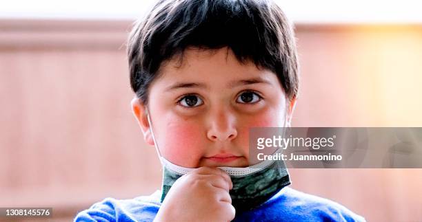 niño pequeño poniéndose una máscara protectora para la cara - chubby boy fotografías e imágenes de stock