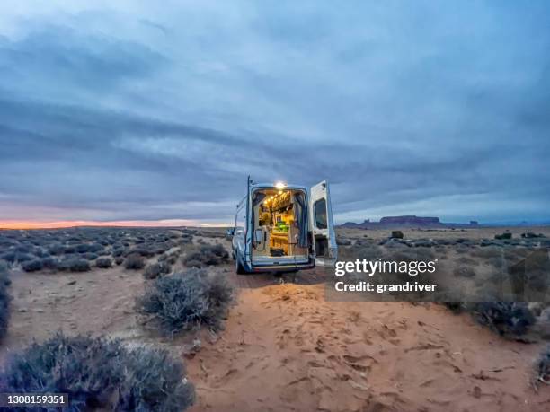 living the conversion van life in monument valley desert, utah and arizona at sunset, cloud scape, the iconic monuments in the background - camping van stock pictures, royalty-free photos & images