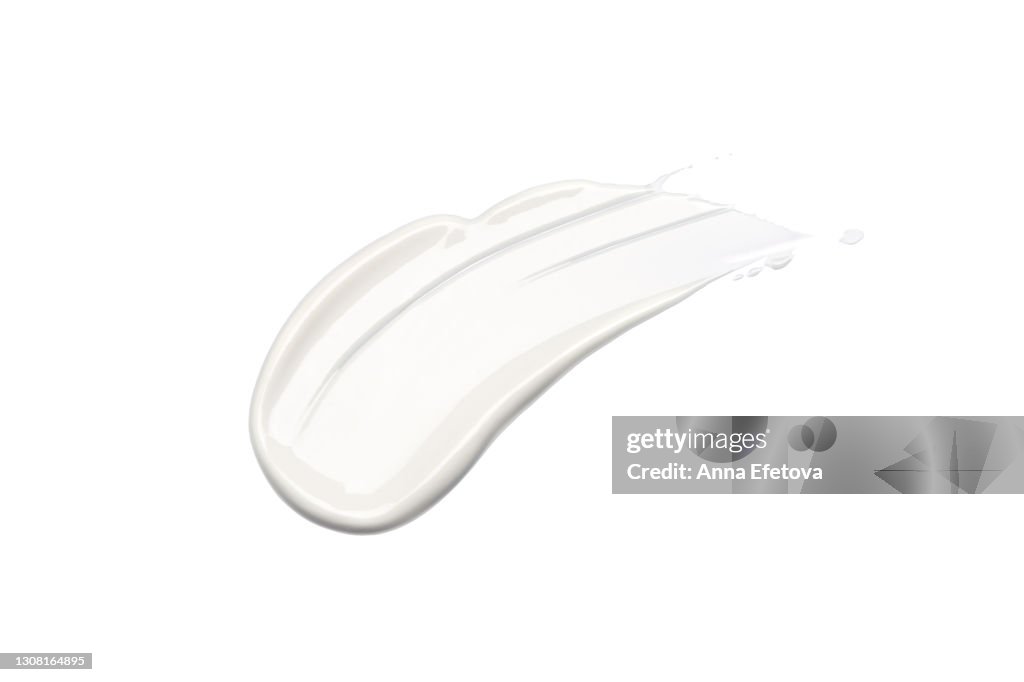 White cosmetics smear on isolated white background. Perfect swatch for advertising and packaging. From above. Flat lay style