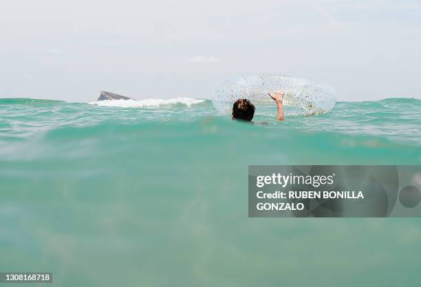 lost caucasian person swimming in the sea with a float to an island - the castaway ストックフォトと画像