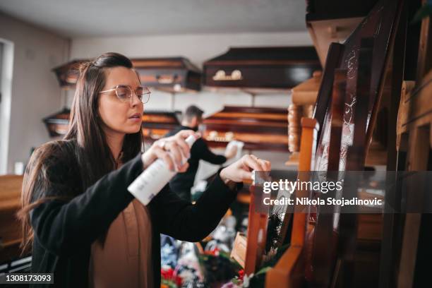 a worker cleans the funeral equipment shop - funeral merchandise stock pictures, royalty-free photos & images