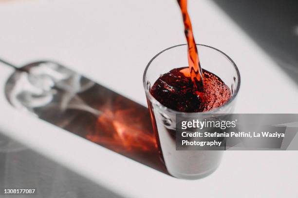 red fruit juice pouring in a drinking glass - saft stock-fotos und bilder