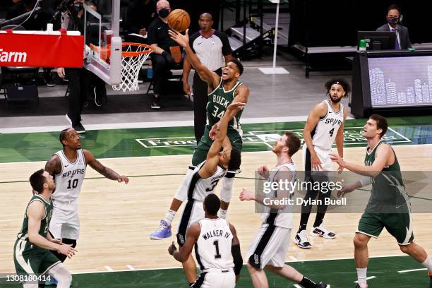 Giannis Antetokounmpo of the Milwaukee Bucks attempts a shot while being guarded by Keldon Johnson of the San Antonio Spurs in the first quarter at...