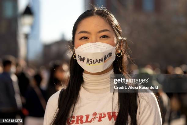 Woman wearing a "stop asian hate" mask poses on the first day of spring in Washington Square Park on March 20, 2021 in New York City. After...