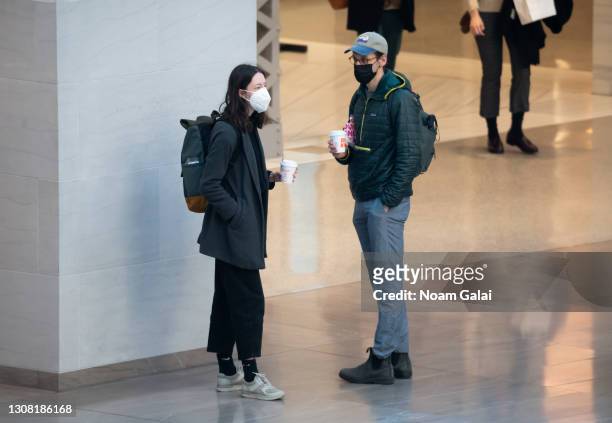People hold Dunkin Donuts coffee cups at Moynihan Train Hall amid the coronavirus pandemic on March 20, 2021 in New York City. After undergoing...