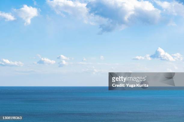 blue sky over the blue ocean - wolkengebilde stock-fotos und bilder