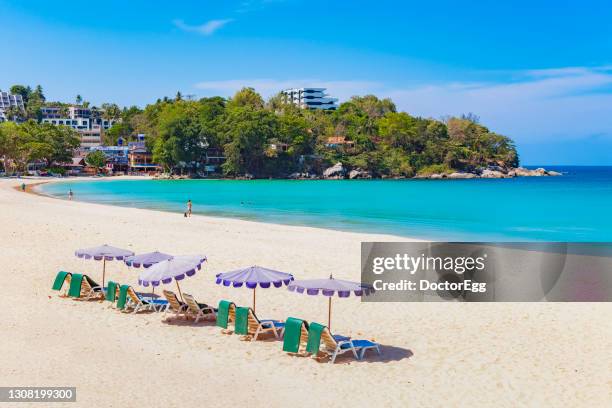 beach bed and umbrella on the white sand beach in summer at kata beach during covid-19, phuket, thailand - kata beach resort on phuket stock-fotos und bilder
