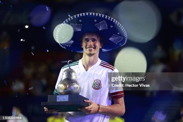 Alexander Zverev of Germany celebrates while raising the champions trophy after winning the final match between Stefanos Tsitsipas of Greece and...