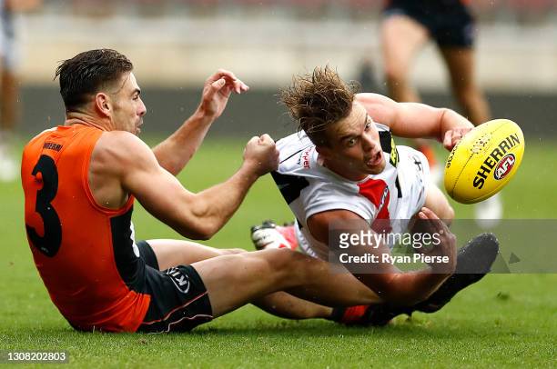 Thomas Highmore of the Saints is tackled by Stephen Coniglio of the Giants during the round one AFL match between the GWS Giants and the St Kilda...