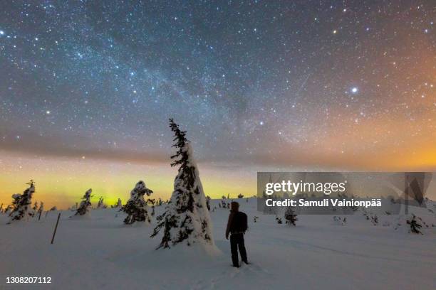 man looking at the stars on a snow capped fell - riisitunturi, posio - finnish lapland - andromeda galaxy stock pictures, royalty-free photos & images