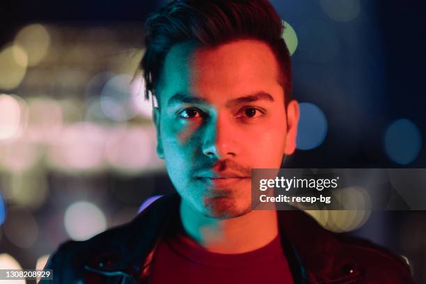 portret van jonge en knappe indische mens die door neonlichten bij nacht wordt aangestoken - indian male model stockfoto's en -beelden