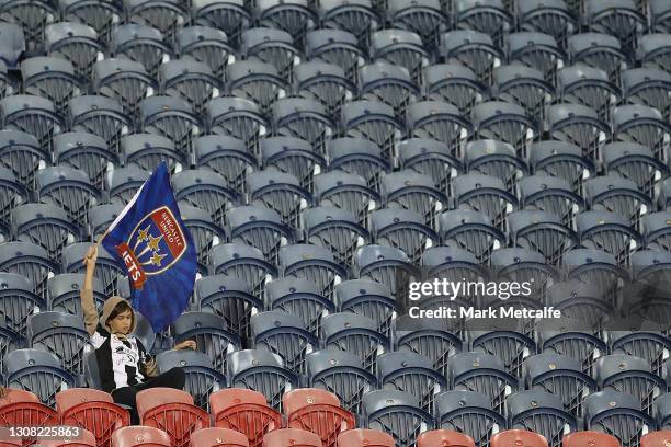 Lone Jets fan waves a flag during the A-League match between the Newcastle Jets and Adelaide United at McDonald Jones Stadium, on March 21 in...