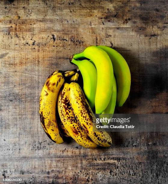 fresh, green, and spoiled bananas on wooden background - ripe 個照片及圖片檔