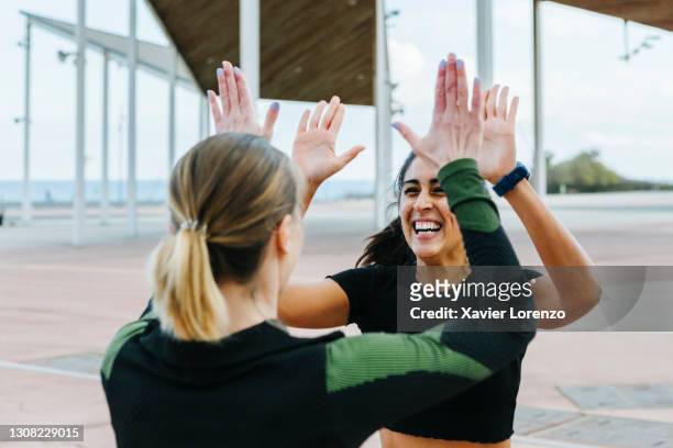 sporty friends giving a high-five after workout together. - deporte equipo fotografías e imágenes de stock