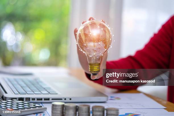 business accounting with saving money with hand holding lightbulb concept financial background - power of print media stock pictures, royalty-free photos & images