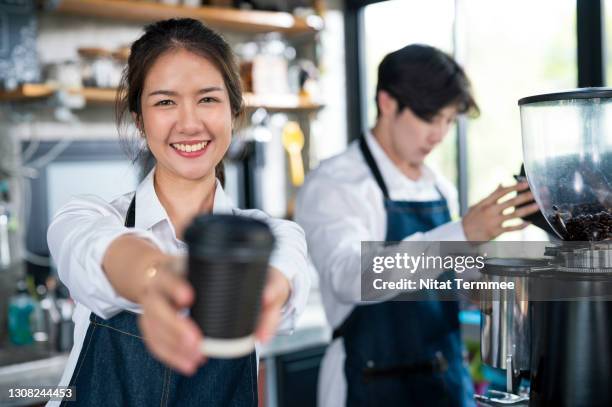 shot of coffee shop owner serving a cup of coffee to her customer at the counter. small business owner, service mind and customer service. - inside coffe store stock pictures, royalty-free photos & images