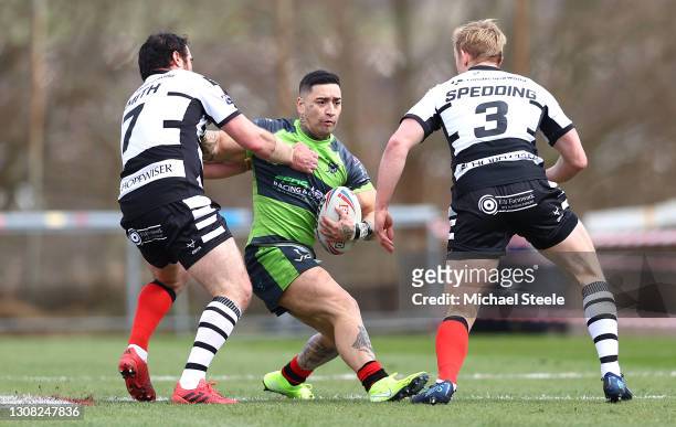 Rangi Chase of West Wales Raiders is tackled by Matty Smith and Jake Spedding of Widnes Vikings during the Betfred Challenge Cup match between West...