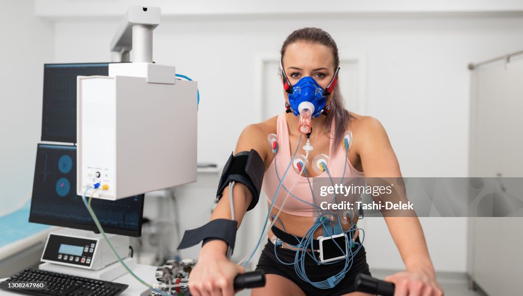 Female Athlete Performing ECG and VO2 test on Indoor Bicycle