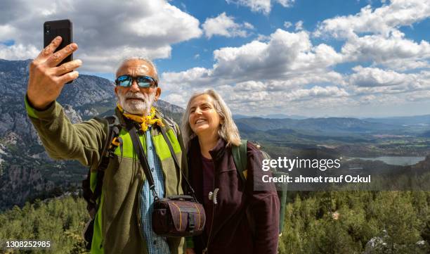 älteres paar macht selfie in der natur, gegen die landschaft - old couple adventure stock-fotos und bilder