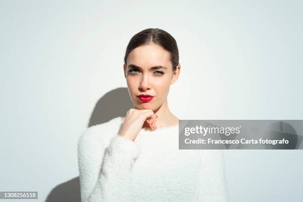 beautiful woman with hand on chin - smart studio shot stock pictures, royalty-free photos & images