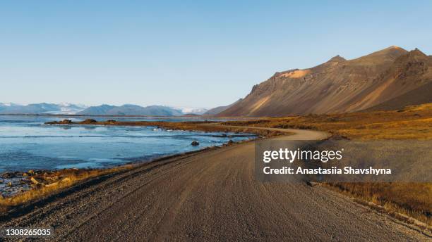 scenic view of the mountain road through the sea coastline during sunrise in iceland - mountain road stock pictures, royalty-free photos & images