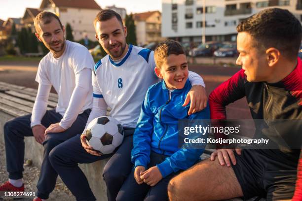 jungs sitzen nach dem spiel auf der bank - bank müde frühling stock-fotos und bilder