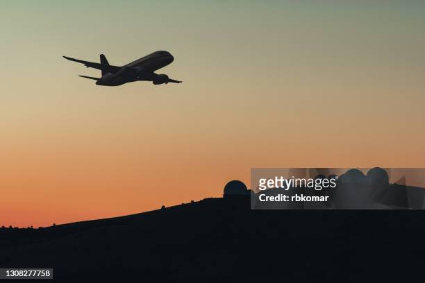 military radio radars with satellite searches silhouette of a commercial or transport jet airplane flying in the mountains. station of surveillance at the military base carries control and intelligence service of the airspace in the dark sky at night - air crash investigation stock pictures, royalty-free photos & images