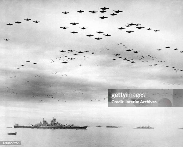 Corsairs and F6F Hellcats fly in formation above the USS Missouri, left foreground, during Japanese World War 2 surrender ceremonies, September 1945....