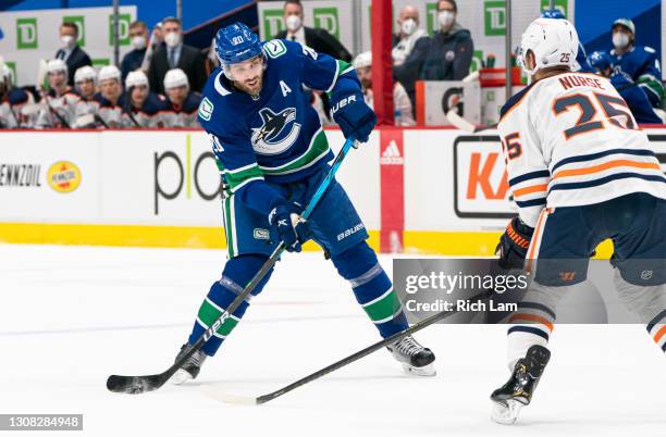 Brandon Sutter of the Vancouver Canucks tries to shoot the puck past Darnell Nurse of the Edmonton Oilers during NHL action at Rogers Arena on March...