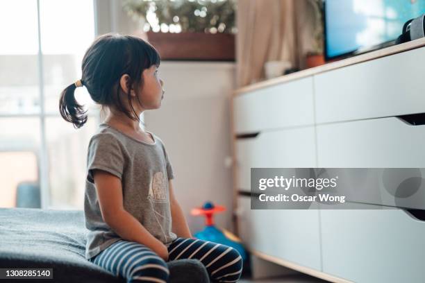 little asian girl watching television - vision films stock pictures, royalty-free photos & images