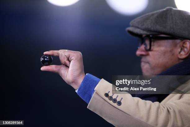 Dion Dublin, BBC Sport TV Presenter picks out a ball during the FA Cup Semi Final draw made at half time from inside the stadium during the Emirates...