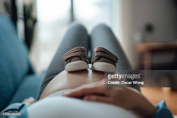 pregnant woman expecting a new life - baby booties stock pictures, royalty-free photos & images