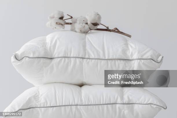 soffici cuscini di cotone bianco con un ramo di cotone in cima - pillow foto e immagini stock