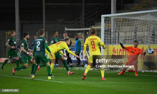 Philipp Lienhart of SC Freiburg scores their side's second goal past Rafał Gikiewicz of Augsburg during the Bundesliga match between Sport-Club...