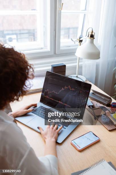 femme d’affaires anonyme analysant des diagrammes financiers sur son ordinateur portatif - action plan photos et images de collection