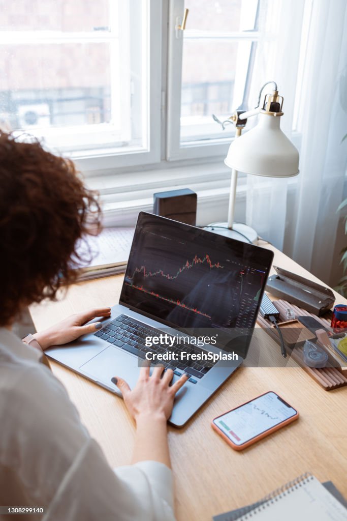 Anonymous Businesswoman Analyzing Financial Charts on her Laptop