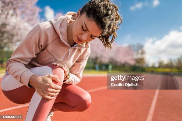 joven deportiva con lesión de rodilla. - knee fotografías e imágenes de stock