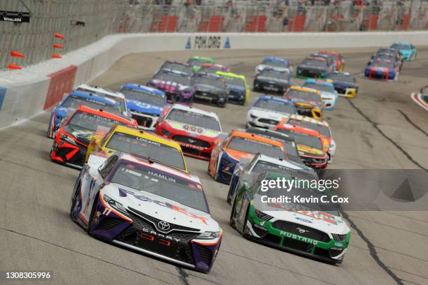 Denny Hamlin, driver of the FedEx Express Toyota, and Kevin Harvick, driver of the Hunt Brothers Pizza Ford, lead the field during the NASCAR Cup...