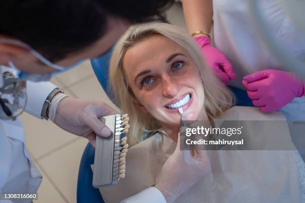 dentiste utilisant un échantillon de couleur de dent de palette - pick tooth photos et images de collection