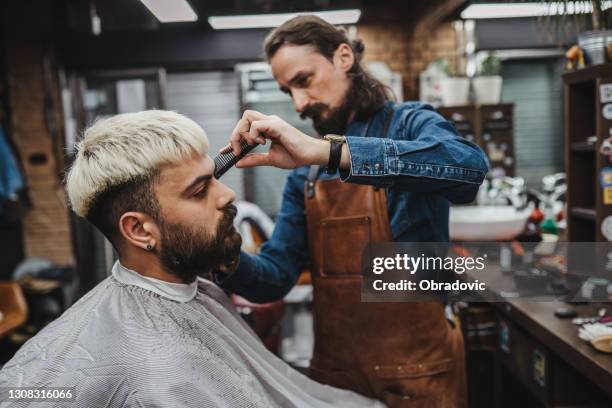 friseur gibt eine rasur in seinem geschäft - barbier stock-fotos und bilder